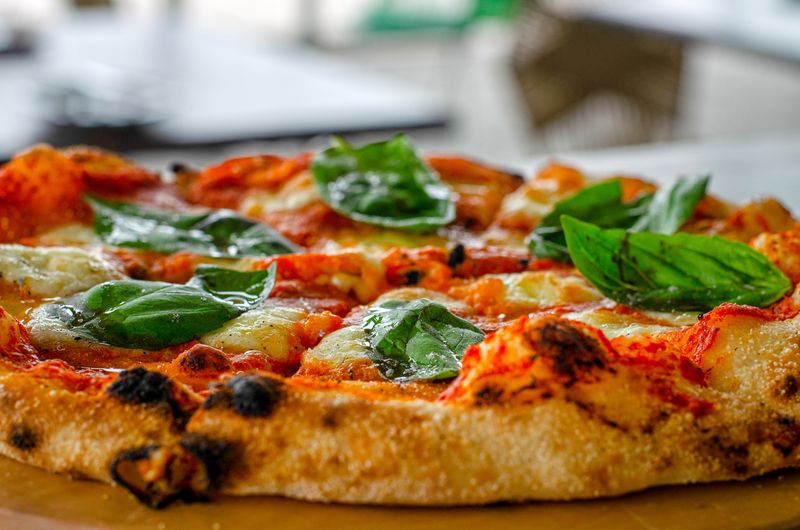 Artisan pizza being crafted by pizzaluce kitchen team members